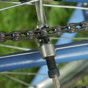 Using a bicycle chain tool to drive out a link pin.
